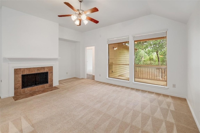 unfurnished living room with lofted ceiling, a fireplace, baseboards, ceiling fan, and carpet flooring