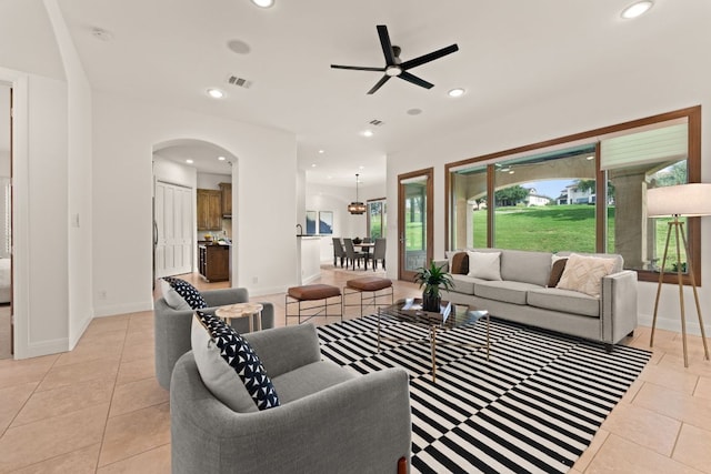 living area with visible vents, arched walkways, a ceiling fan, and recessed lighting