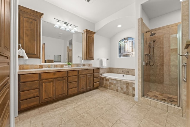 bathroom with a shower stall, a sink, and a garden tub