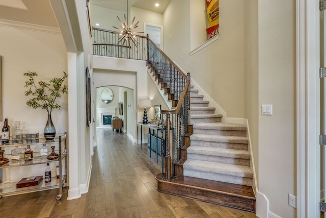4101 Front Range Ln, Austin, TX 78732 - entryway with crown molding, baseboards, an inviting chandelier, stairs, and hardwood / wood-style floors