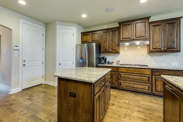4101 Front Range Ln, Austin, TX 78732 - kitchen featuring appliances with stainless steel finishes, backsplash, under cabinet range hood, and light wood-type flooring