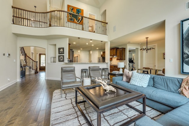 4101 Front Range Ln, Austin, TX 78732 - living room with arched walkways, dark wood-type flooring, a high ceiling, stairs, and a chandelier
