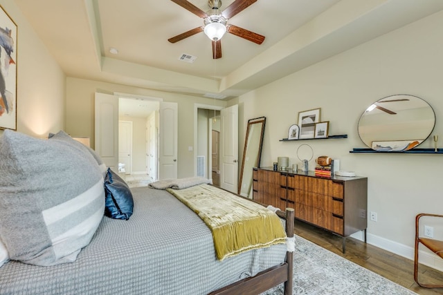 4101 Front Range Ln, Austin, TX 78732 - bedroom featuring ceiling fan, a raised ceiling, baseboards, wood finished floors, and visible vents