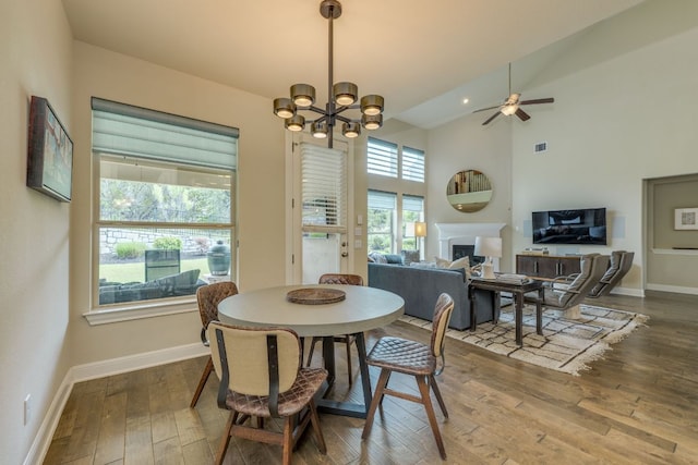 4101 Front Range Ln, Austin, TX 78732 - dining space featuring hardwood / wood-style flooring, a chandelier, a fireplace, a ceiling fan, and vaulted ceiling