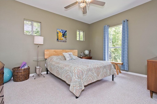 bedroom with a ceiling fan, baseboards, and carpet