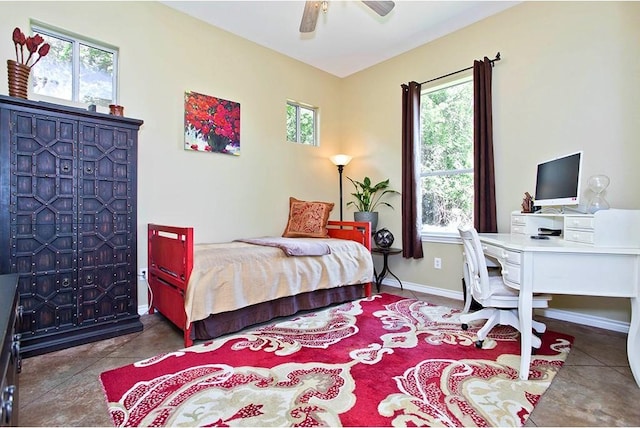 bedroom featuring baseboards, a ceiling fan, and multiple windows