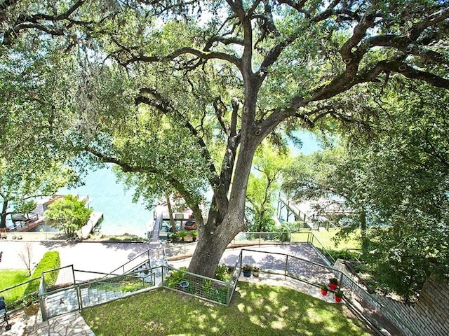 view of property's community with a lawn and fence