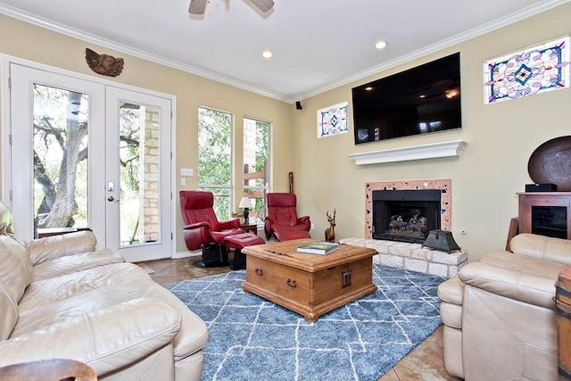 living room featuring crown molding, a fireplace with raised hearth, tile patterned floors, recessed lighting, and a ceiling fan