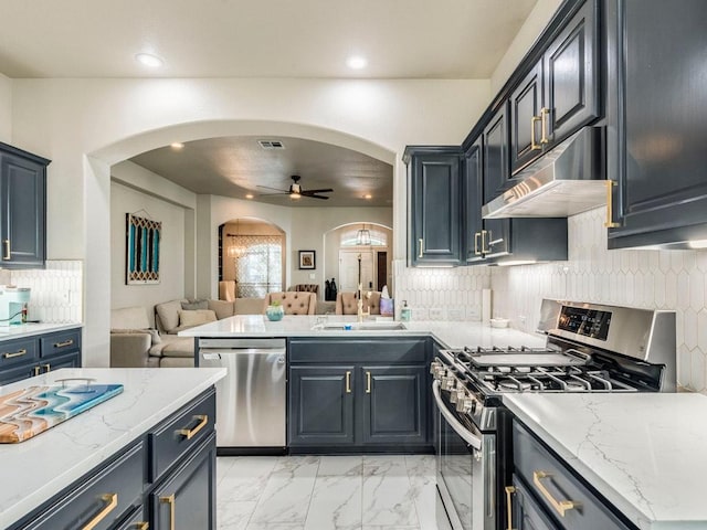 kitchen with a sink, arched walkways, stainless steel appliances, open floor plan, and under cabinet range hood