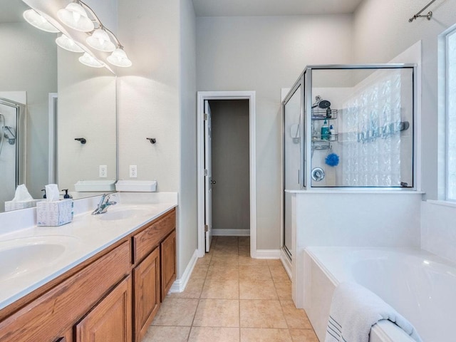 full bathroom with a garden tub, a sink, a stall shower, and tile patterned flooring