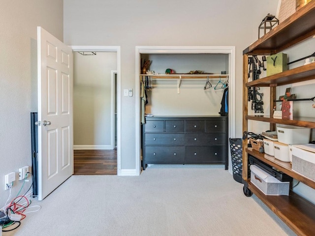 carpeted bedroom featuring baseboards and a closet