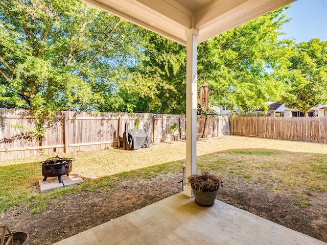 view of yard featuring a fenced backyard, a fire pit, and a patio area