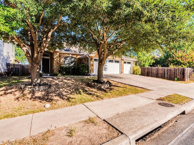 view of front facade featuring a garage, fence, and driveway
