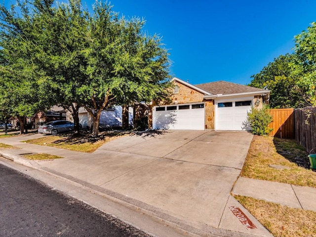 view of front facade with a garage, fence, and concrete driveway