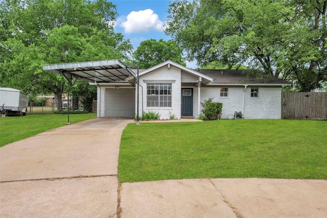 ranch-style home featuring fence, a front yard, concrete driveway, an attached garage, and a carport