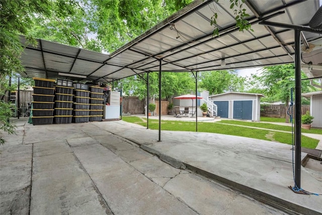 view of car parking featuring fence and a storage unit