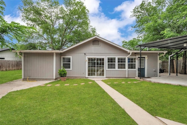 back of house featuring a patio, a lawn, and fence