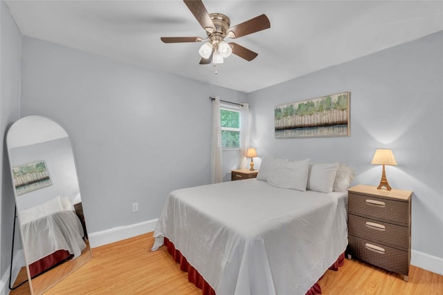 bedroom featuring baseboards, a ceiling fan, and light wood finished floors