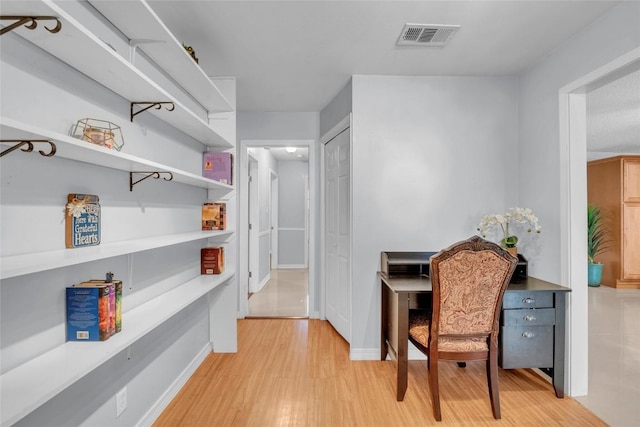 interior space with light wood-style floors, baseboards, and visible vents