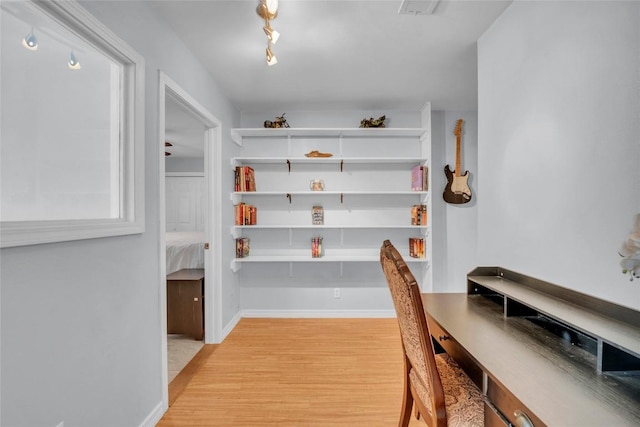 interior space with baseboards and light wood finished floors