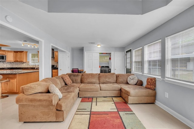 living area featuring light tile patterned flooring and baseboards