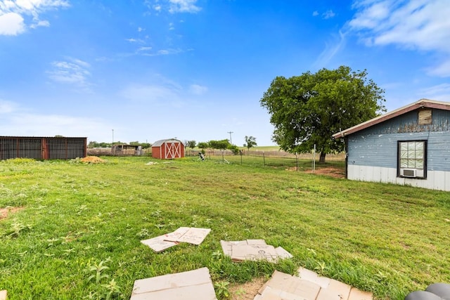 view of yard featuring an outdoor structure, a shed, and fence