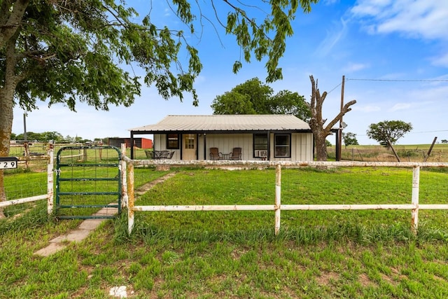 single story home featuring fence, metal roof, and a front yard