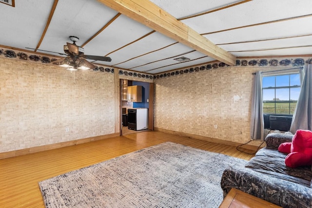 living room featuring a ceiling fan, baseboards, vaulted ceiling with beams, wood finished floors, and visible vents