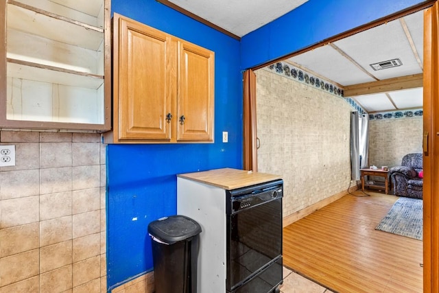 kitchen featuring light countertops, baseboards, wood finished floors, and visible vents