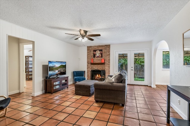 living area with ceiling fan, plenty of natural light, and light tile patterned floors