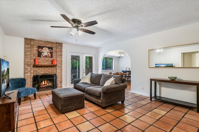 2604 Fentonridge Dr, Austin, TX 78745 - living room with light tile patterned floors, a textured ceiling, arched walkways, ceiling fan, and a chandelier