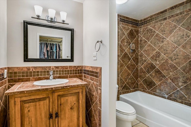 2604 Fentonridge Dr, Austin, TX 78745 - bathroom featuring tile walls, vanity, toilet, shower / bathtub combination, and tile patterned floors