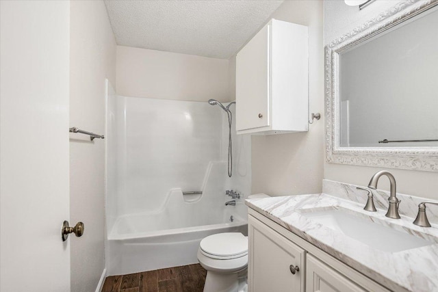 2604 Fentonridge Dr, Austin, TX 78745 - full bathroom with vanity, a textured ceiling, toilet, wood finished floors, and  shower combination
