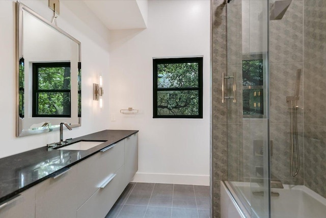 full bath with baseboards, tile patterned flooring, bath / shower combo with glass door, and vanity