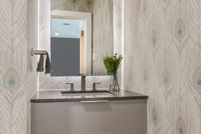 bathroom featuring wallpapered walls, visible vents, and vanity