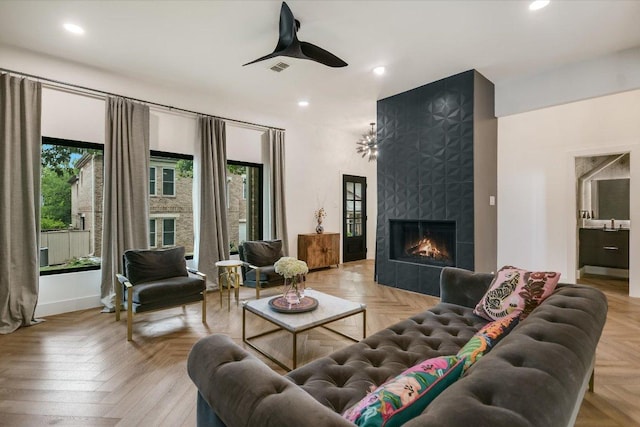 living room featuring recessed lighting, baseboards, ceiling fan, and a tile fireplace