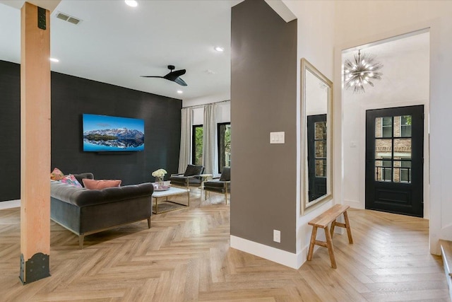 foyer with visible vents, baseboards, ceiling fan with notable chandelier, an accent wall, and recessed lighting