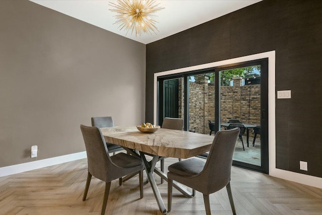 dining room featuring baseboards, a chandelier, and a towering ceiling
