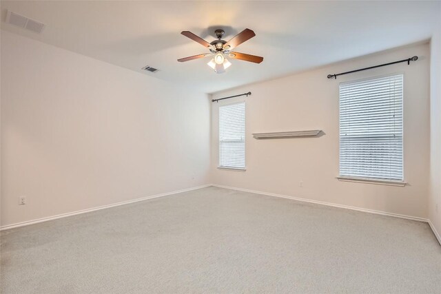 spare room featuring visible vents, a ceiling fan, baseboards, and carpet flooring