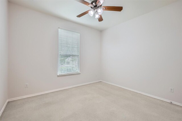unfurnished room featuring a ceiling fan, baseboards, and light colored carpet