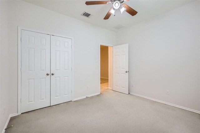 unfurnished bedroom with carpet, a ceiling fan, baseboards, visible vents, and a closet