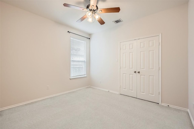 unfurnished bedroom with light colored carpet, baseboards, visible vents, and a closet