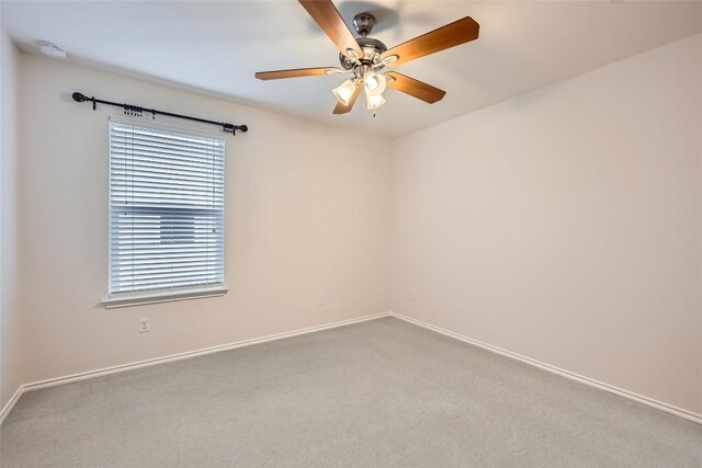 carpeted spare room with baseboards and ceiling fan