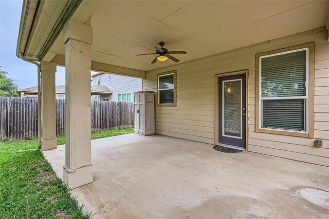 view of patio / terrace with ceiling fan and fence
