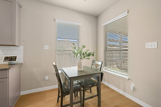dining area with light wood-type flooring, baseboards, and a wealth of natural light