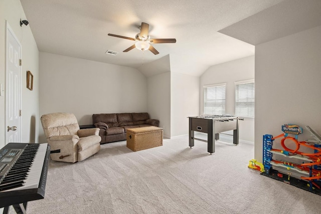 playroom with ceiling fan, carpet floors, baseboards, lofted ceiling, and visible vents