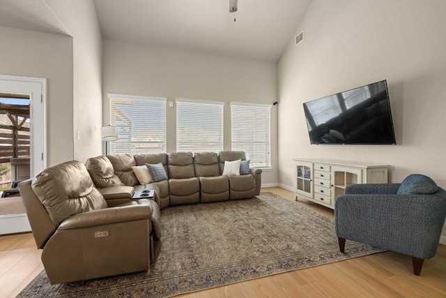 living room featuring high vaulted ceiling, a ceiling fan, wood finished floors, and visible vents