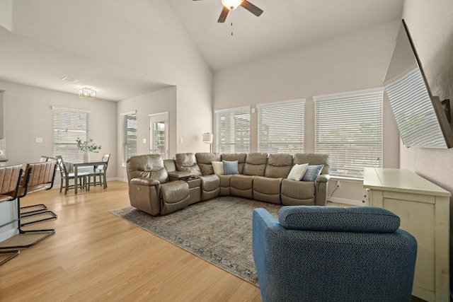 living area featuring plenty of natural light, high vaulted ceiling, ceiling fan, and light wood finished floors