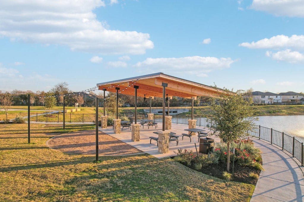 surrounding community featuring a water view, fence, and a yard