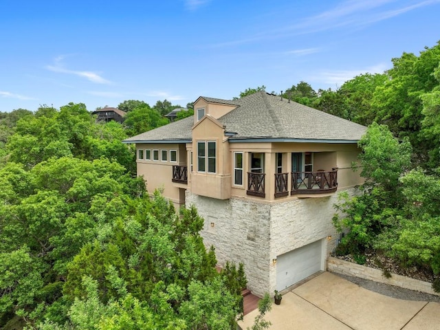 3800 Laurel Ledge Ln, Austin, TX 78731 - view of front of house with stucco siding, a balcony, stone siding, and a shingled roof